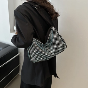 Elegant black hobo bag with sparkling silver rhinestones worn on a model's shoulder