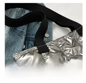 Detail of silver quilted tote bag with metallic texture and black woven handles