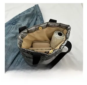Spacious interior of silver quilted tote bag showing umbrella, phone, and wallet storage