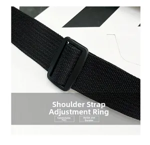 Detail of adjustable woven shoulder strap and plastic buckle on the black crossbody bag