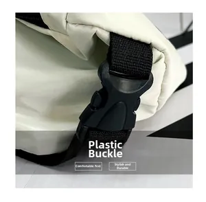 Detail shot of the durable black plastic buckle and strap on the white messenger bag