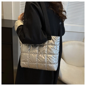 Detailed view of the silver quilted tote bag showing its metallic puffer texture