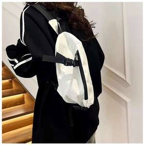Clean shot of a white minimalist crossbody bag with black straps in a home setting