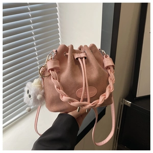 Petit sac seau en daim rose avec poignée tressée et charmant pendentif en peluche