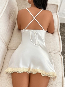 Elegant white satin slip dress with lace trim and criss-cross back bow detail
