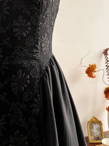 Detailed macro view of black textured jacquard fabric with elegant floral relief patterns