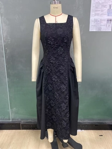 Detailed close-up of French style black sleeveless dress with textured floral jacquard fabric