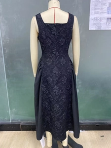 Detail of black midi dress with textured 3D floral jacquard fabric and waist gathering