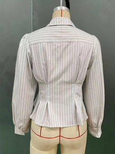Dettaglio della vita aderente a righe verticali e paillettes su una camicia