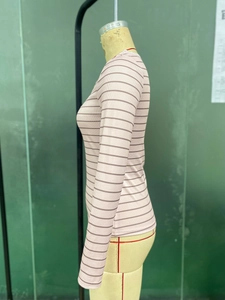 Dettaglio della maglia a maniche lunghe a righe rosa con trama a costine e polsini rifiniti