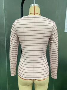 Dettaglio della maglia a maniche lunghe a righe rosa con pizzo bianco e trama a coste