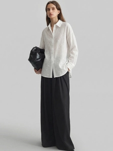 Detail showing white long-sleeve crepe shirt with textured fabric and classic collar