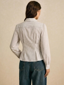 Dettaglio del retro della camicia a righe con pieghe in vita e sottili righe verticali