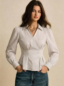 Dettaglio della camicia a righe sciancrata con bottoni decorativi e scollo a V raffinato
