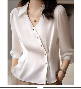 Detailed view of white satin shirt featuring diagonal placket and golden ball buttons