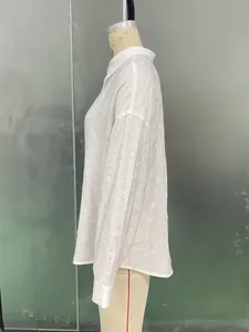 Detail view of white long-sleeve textured crepe shirt with buttoned cuffs and loose fit