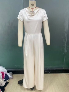 Detail of elegant champagne satin jumpsuit with cowl neck and high-waist wide leg cut