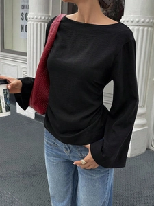 Detail of black long sleeve top with flared split cuffs and micro-crinkle texture