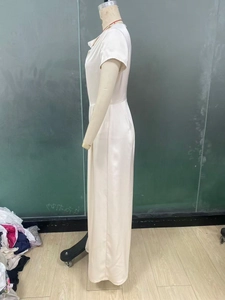 Detail of elegant champagne pink satin jumpsuit showing silky texture and draped neckline