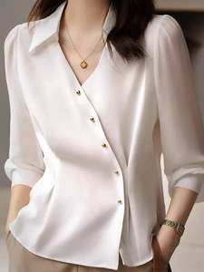 Detail of elegant satin shirt featuring golden buttons and diagonal placket design