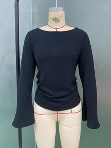Detail view of the elegant bell sleeves and textured black fabric on this boat neck top