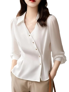 Detail of white satin shirt featuring diagonal gold buttons and asymmetric closure