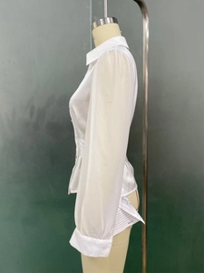 Detailed side view of a white satin long-sleeve shirt showing the glossy fabric texture