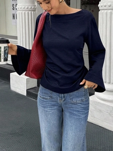 Navy long-sleeve blouse with flare cuffs and round neck paired with blue jeans