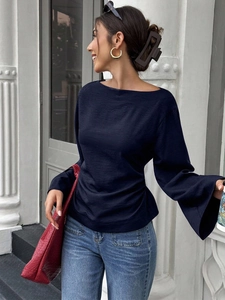 Detail of elegant navy bell sleeves and textured fabric on women's boat neck blouse