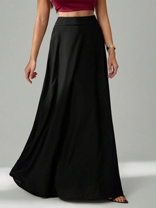 Détail d'une jupe longue noire taille haute montrant le tissu fluide et le drapé plissé