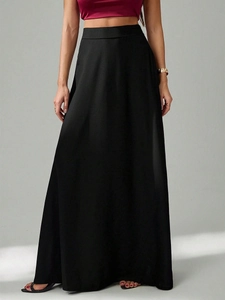 Détail de la taille haute élégante et du tissu noir fluide de cette jupe longue chic