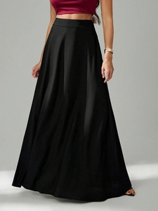 Détail de la jupe longue noire en satin taille haute avec drapé élégant et texture soyeuse
