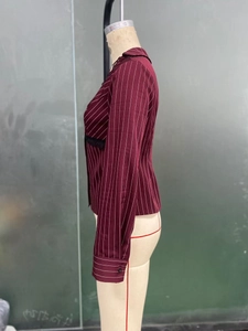 Close-up of burgundy striped shirt featuring black lace trim and buttoned cuffs details
