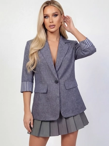 Détail de la manche du blazer gris avec doublure rayée bleue et blanche et tissu texturé