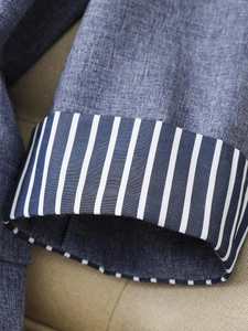 Detail of navy textured blazer cuff featuring stylish blue and white striped lining trim