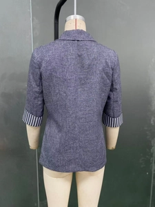 Detail view of women's grey blazer with striped three-quarter sleeve cuffs on mannequin