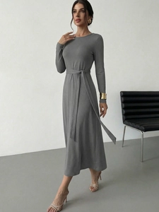 Detail of grey knitted long sleeve maxi dress with matching belt and elegant A-line silhouette