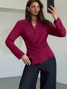 Detail of a deep magenta wrap style shirt with a slim waist design and V-neckline
