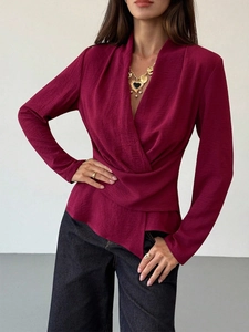Detail of burgundy long sleeve blouse with elegant crossed waist and pleated texture