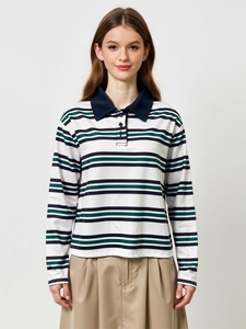 Détail du polo rayé montrant le col contrasté, la patte à trois boutons et la texture du tissu