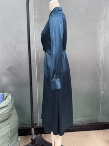 Side view of dark teal satin long sleeve A-line midi dress with waist cinch detail
