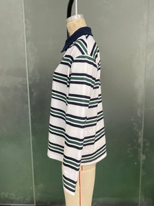 Détail d'un polo à rayures bleu marine et vert avec col sur mannequin de femme