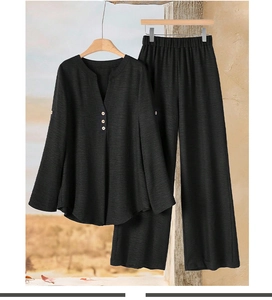 Detail of black two-piece set with V-neck button top and wide-leg textured pants