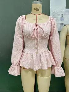 Detail der rosa französischen Bluse mit floralem Jacquard-Stoff und zarten Perlenknöpfen