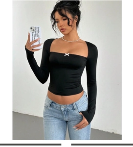 Detail of square neckline with small white bow on black slim long sleeve crop top