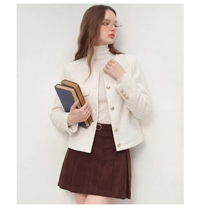 Détail d'une veste en tweed blanc avec boutons métalliques et texture de style français