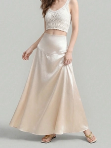 Detail showing the glossy texture and elegant drape of the champagne satin midi skirt
