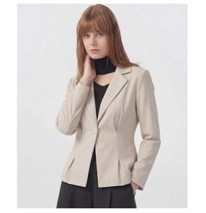 Détail de blazer beige cintré montrant le revers cranté et les plis à la taille