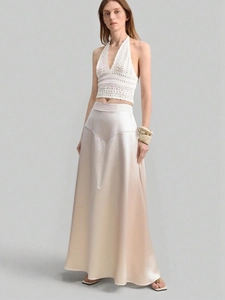 Detail of high-waisted champagne satin skirt with premium silky texture and soft sheen