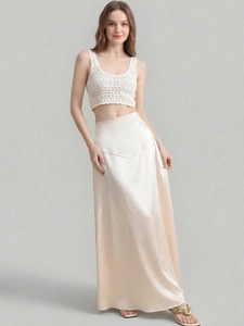 Detailed texture of white crochet knit top paired with champagne satin midi skirt